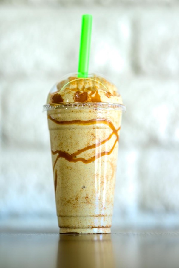 A blended drink with syrup drizzle in a Best Life Nutrition cup